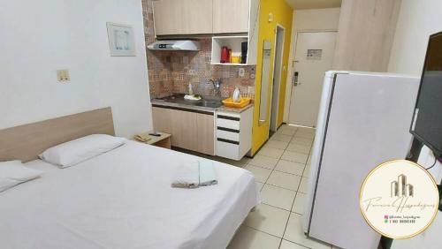 a small room with a bed and a kitchen at Flat Bellagio - suítes econômicas - Ferreira Hospedagens in São Luís