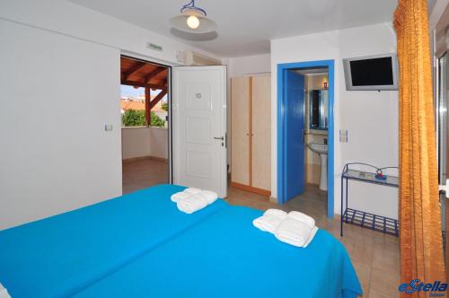 a bedroom with a blue bed with towels on it at Estella Studios in Elafonisos