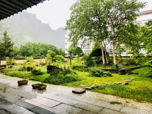 a view of a garden with plants and trees at Choyo Tei in Kamikawa