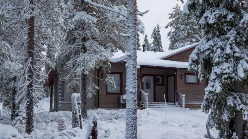 a cabin in the woods with snow covered trees at Ruka Saukonmaja A in Ruka