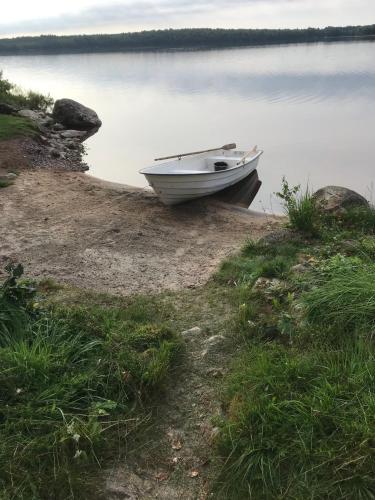 a small boat sitting on the shore of a lake at Joarsbo, Stuga 1, Sjölyckan in Kalv