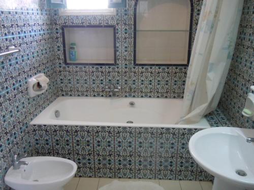 łazienka z wanną, toaletą i umywalką w obiekcie House with Wala Garden w mieście Mahdia