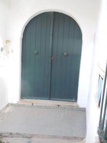 an archway with a blue door in a white building at House with Garden Wala in Mahdia