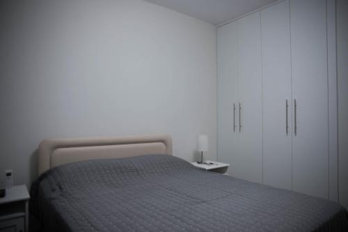 a white bedroom with a bed and white cabinets at One bedroom apartment in Paphos in good location in Paphos