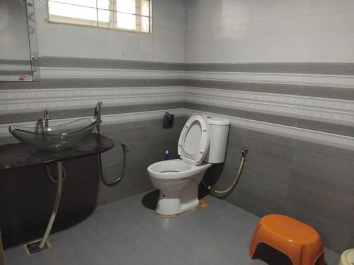 y baño con aseo y lavamanos. en Vamoose Friendz Homestay, en Sakleshpur