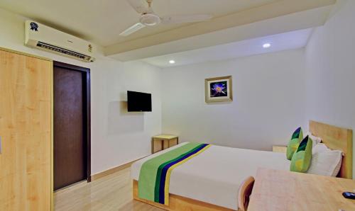 a bedroom with a bed and a tv on a wall at Treebo Innside in Chennai