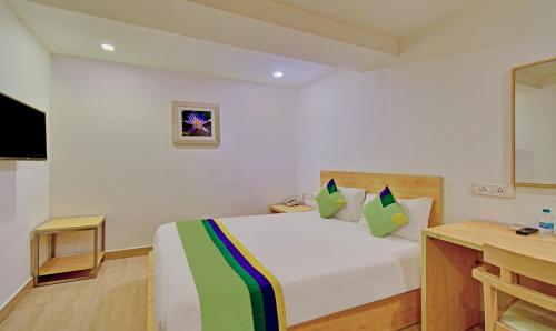 a bedroom with a bed and a desk and a television at Treebo Innside in Chennai
