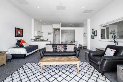 a living room with a couch and a coffee table at Auckland Waterfront Serviced Apartments on Prince's Wharf in Auckland