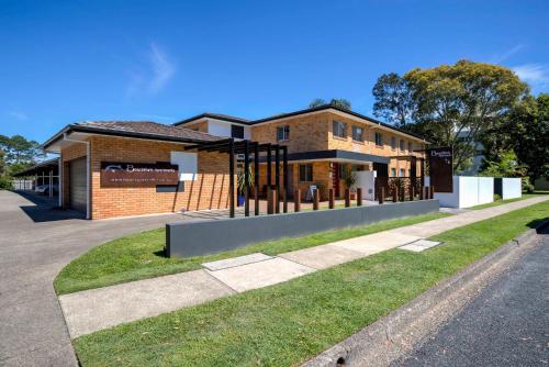 a large wooden building with a fence on the side of it at Beachpark Apartments Coffs Harbour in Coffs Harbour