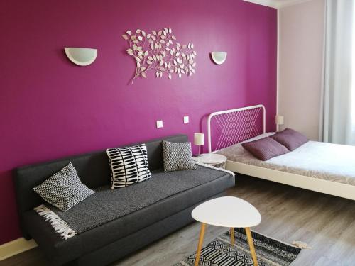 Varennes-en-ArgonneにあるHotel du Grand Monarqueの紫の壁のリビングルーム(ソファ付)