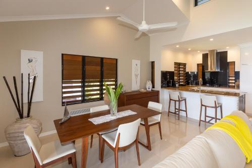 a dining room and kitchen with a table and chairs at Anchorage Apartments on Hamilton Island by HIHA in Hamilton Island