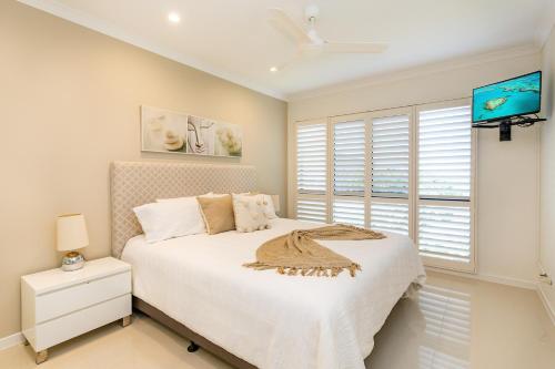 a bedroom with a white bed and a window at Anchorage Apartments on Hamilton Island by HIHA in Hamilton Island