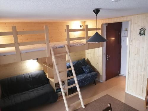 Ce lit superposé se trouve dans un dortoir doté d'un canapé et d'une échelle. dans l'établissement Studio 6 places, à Bagnères-de-Bigorre