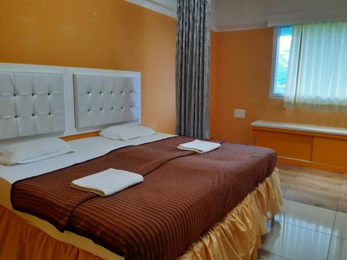 a bedroom with a large bed with two towels on it at Niasha Youth Hostel in Ullāl