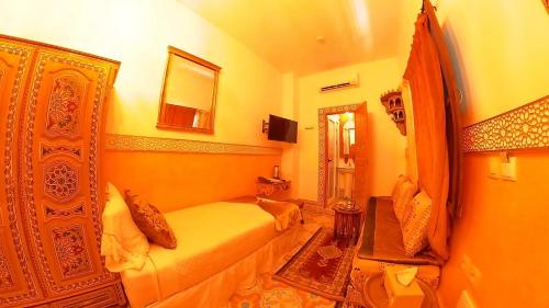 a hotel room with a bed and a mirror at Riad Las Mil y una Noches Tetuan in Tetouan
