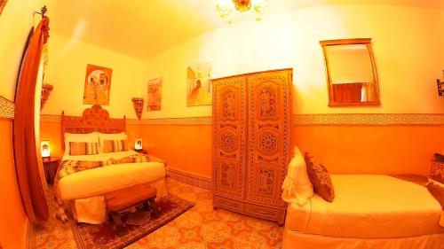 a hotel room with two beds and a mirror at Riad Las Mil y una Noches Tetuan in Tetouan