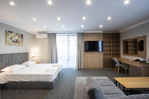 une chambre d'hôtel avec un lit et un canapé dans l'établissement Avenue Hotel Deluxe, à Bourgas