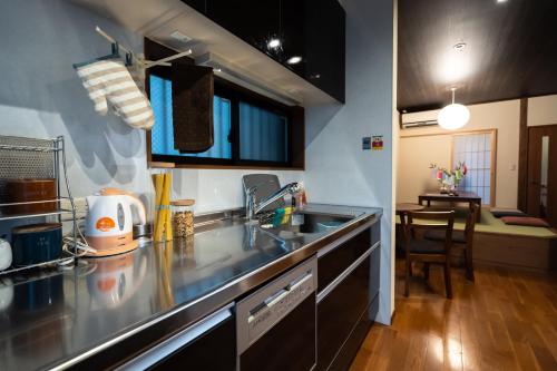 een keuken met een spoelbak en een aanrechtblad bij Guesthouse Nobi in Kyoto