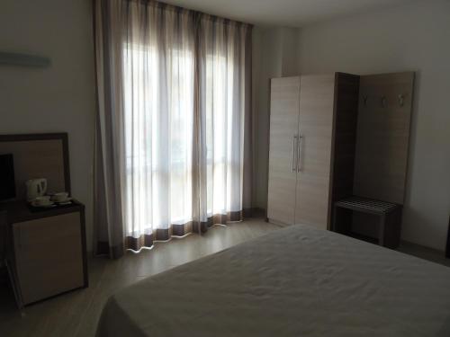 a bedroom with a bed and a large window at Hotel Lido Inn in Lido di Camaiore