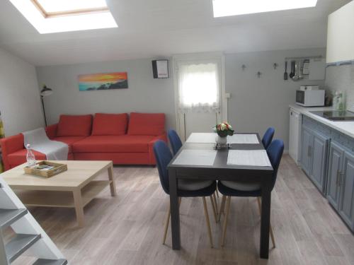 a living room with a red couch and a table at La Belle symphonie in Vieil-Moutier