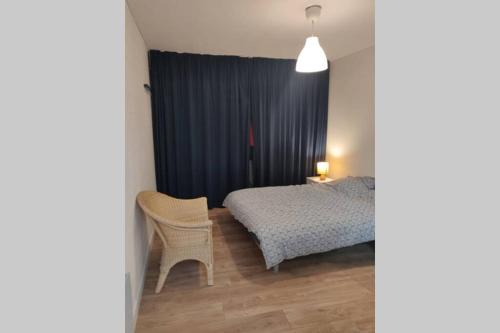 ein Schlafzimmer mit einem Bett, einem Tisch und einem Stuhl in der Unterkunft Clos Saint Jacques in Thann