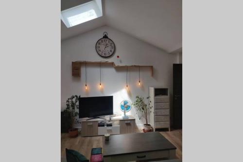 a living room with a clock on the wall at Clos Saint Jacques in Thann