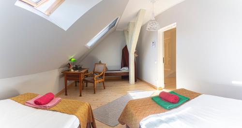 a attic room with two beds and a table at Guesthouse Kadrina Mõis in Kadrina