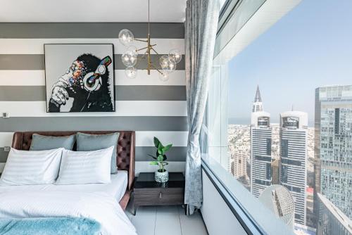 a bedroom with a bed and a balcony with a view at Index Tower by Radiance Vacation Stays 47th Floor in Dubai
