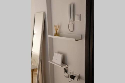 ein Badezimmer mit einem Spiegel und einem Telefon an der Wand in der Unterkunft Luxury Townhouse in Larisa