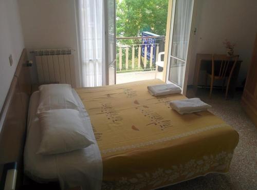 a bed in a room with a large window at PENSIONE GARDENIA in Finale Ligure