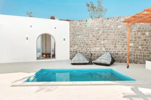 a swimming pool in front of a brick wall at Oyster Luxury Suites in Imerovigli