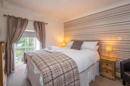 Un dormitorio con una cama grande y una ventana en The Nags Head Inn, en Abercych
