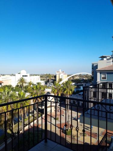 a balcony with a view of the ocean and palm trees at Island Club by Smart City Stays in Cape Town