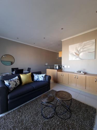 a living room with a couch and a table at Island Club by Smart City Stays in Cape Town