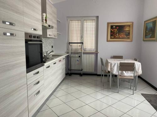 una cocina con armarios blancos y una mesa con mantel en Villa Ulivi, en Tocco da Casauria