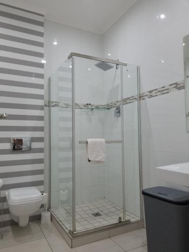 a bathroom with a shower with a toilet and a sink at Island Club by Smart City Stays in Cape Town