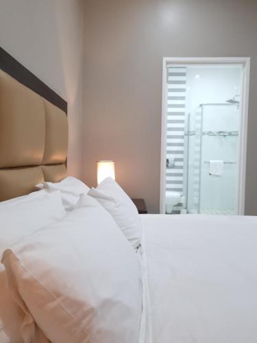 a white bed in a room with a window at Island Club by Smart City Stays in Cape Town