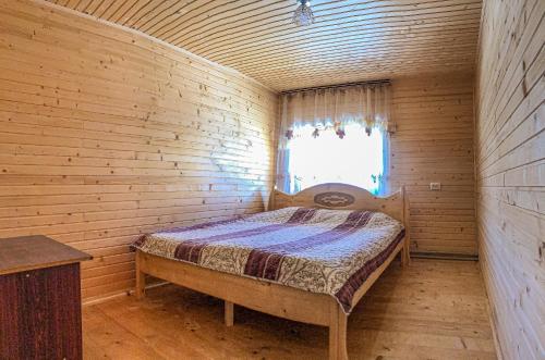 een slaapkamer met een bed in een houten kamer bij Вілла Зозуля in Mykulychyn