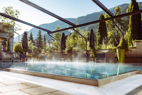 a pool at a hotel with a fountain at Alpen-Karawanserai in Saalbach Hinterglemm