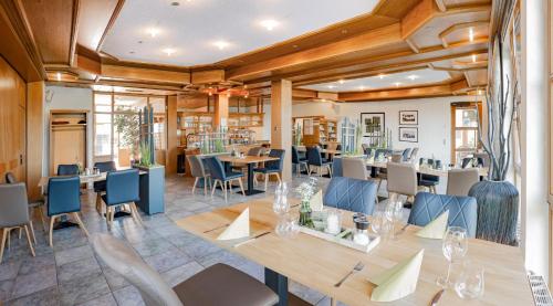 ein Restaurant mit Holzdecken, Tischen und Stühlen in der Unterkunft Landhotel Kirchberg in Kirchberg an der Jagst