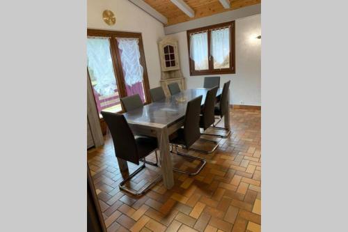 une salle à manger avec une table et des chaises noires dans l'établissement Gîte de campagne, à Rosureux
