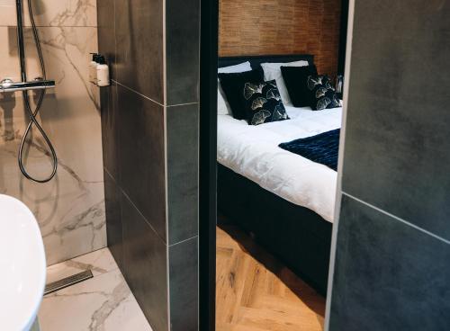 a bedroom with a bed and a bathroom at B&B Bardot in Purmerend
