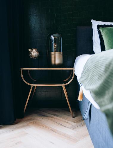 a night stand next to a bed in a bedroom at B&B Bardot in Purmerend