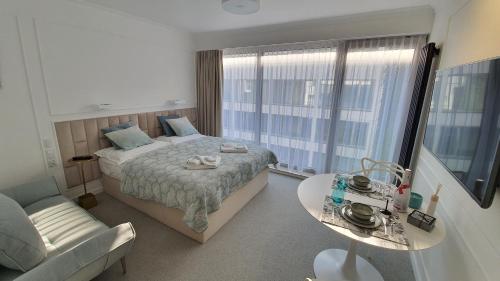 a bedroom with a bed and a table and a couch at Lividus 432 By Edyta in Świnoujście