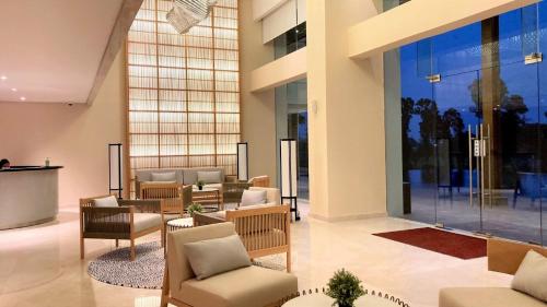 a lobby with chairs and tables in a building at Kawana Golf Residence in Cikarang