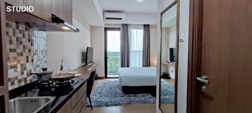 a hotel room with a bathroom with a bed and a sink at Kawana Golf Residence in Cikarang