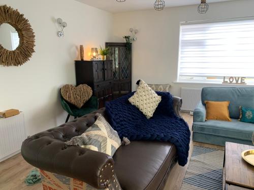 a living room with a brown couch and a blue chair at Shore Lodge. 4 bed bungalow only mtrs from the beach. Sleeps 8 in Sutton on Sea