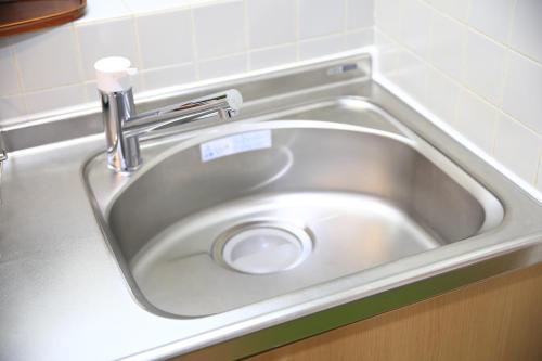 - un évier en argent avec un robinet dans la cuisine dans l'établissement 【渋谷35】光回線完備のお部屋＜Rewrite＞, à Tokyo