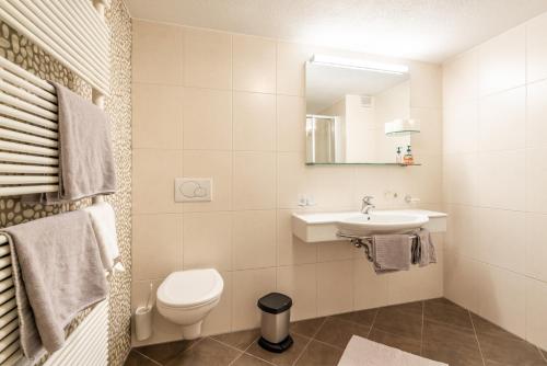 a white bathroom with a toilet and a sink at Appartements Mair in Mayrhofen