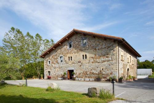 a large stone building with a red door at Heredad de Unanue in Donostia-San Sebastián